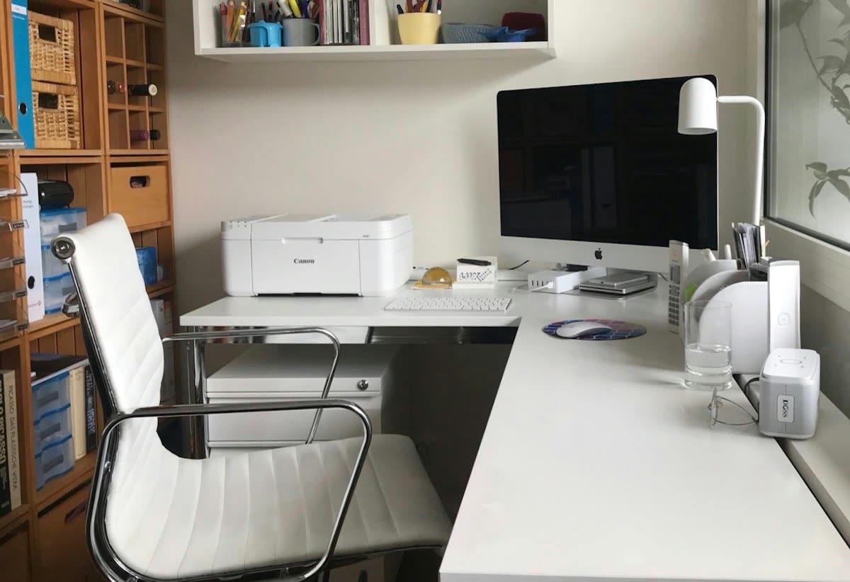 Home office desk with a white printer beside an iMac