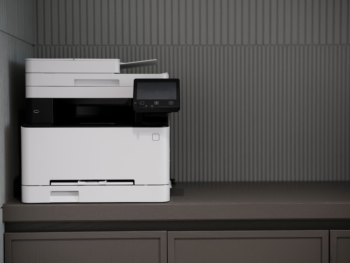 Colour laser multifunction printer with a touchscreen on an office cabinet
