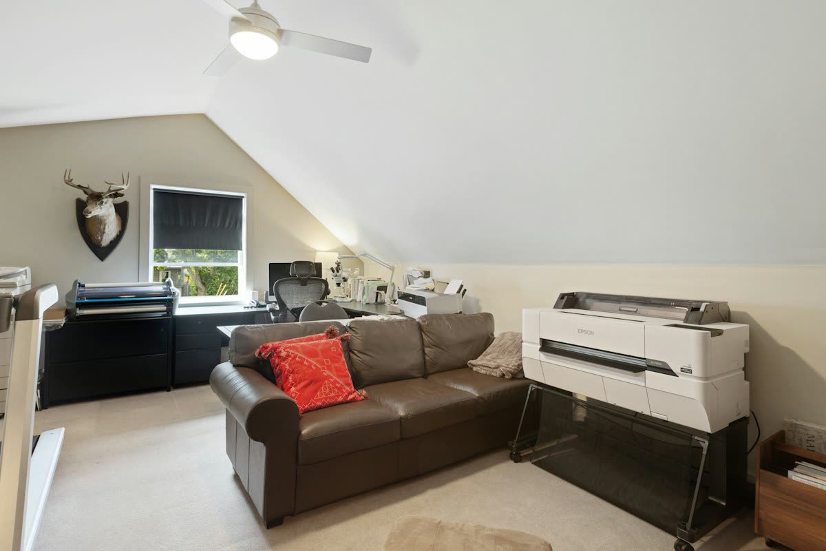 Loft home office with a large-format printer beside a sofa