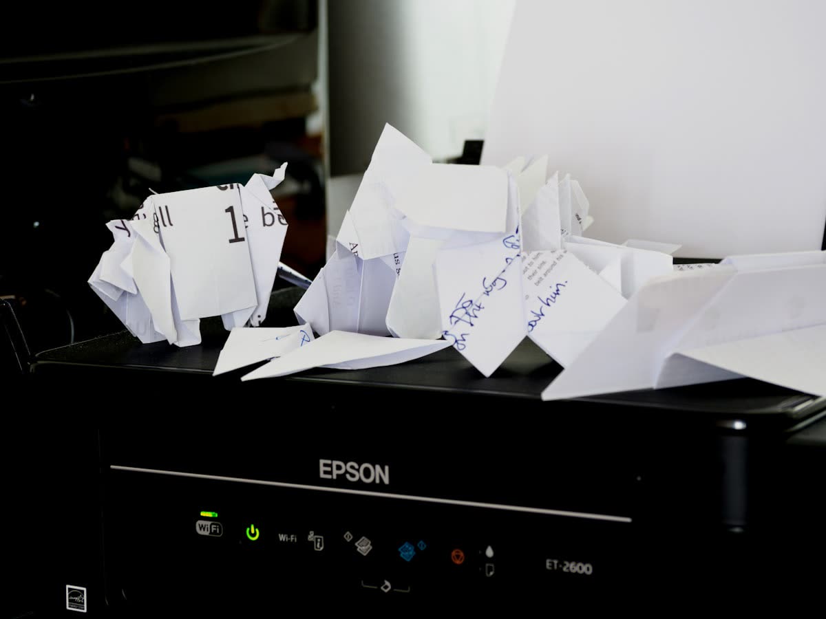 Crumpled paper piled on an Epson printer after a misfeed