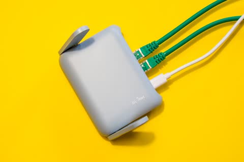 Router with cables plugged in, on yellow background