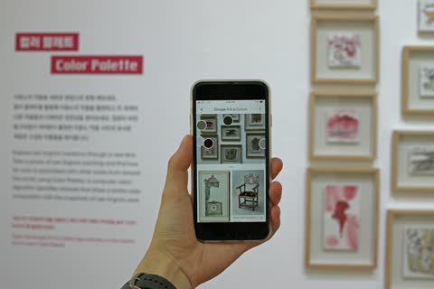 Hand holding a smartphone showing a photo gallery