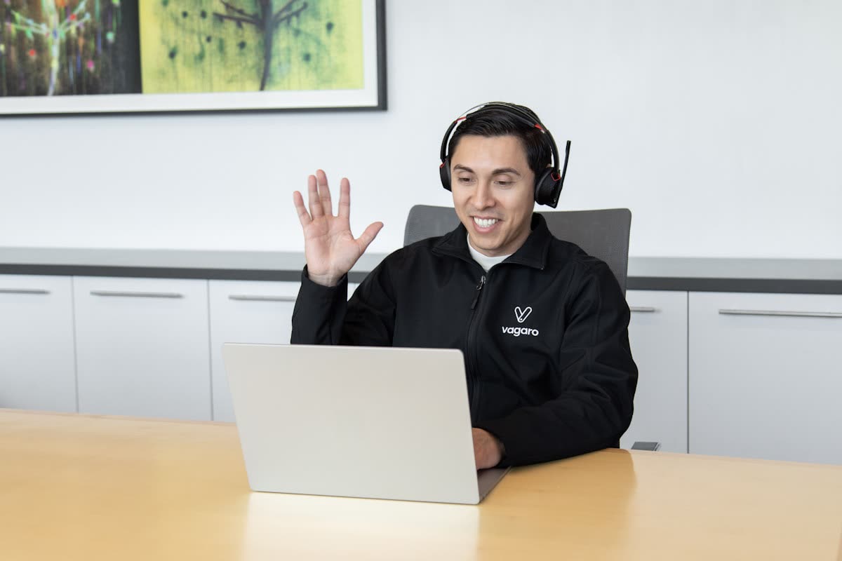 Support agent with a headset waving on a video call
