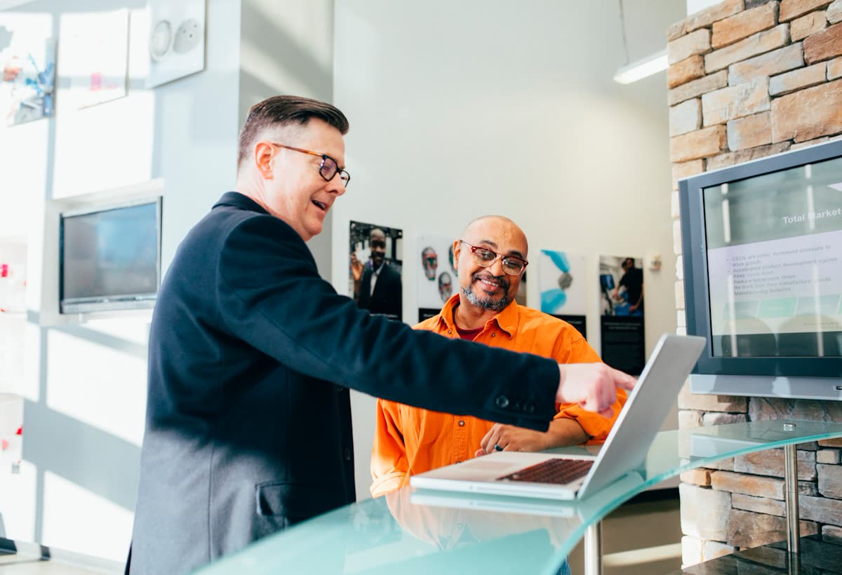 Two colleagues looking at a laptop in an office