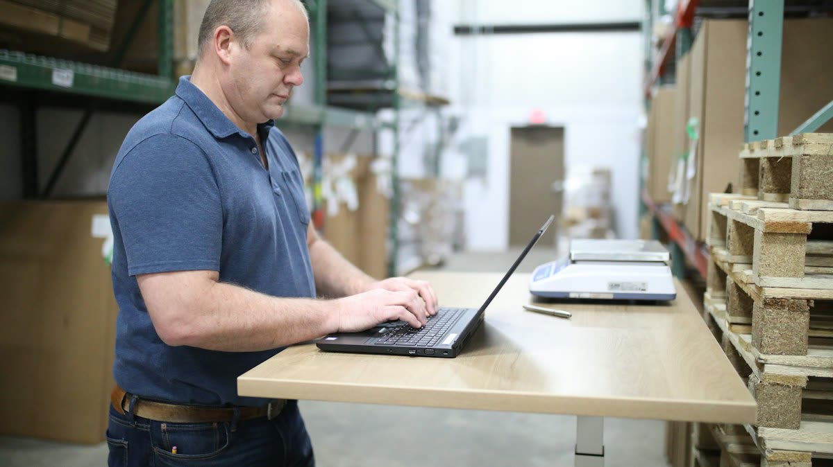 Man working at a laptop on a standing desk