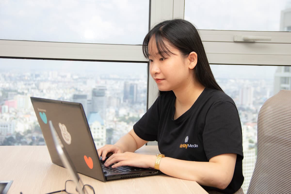 Woman working on a laptop by a window