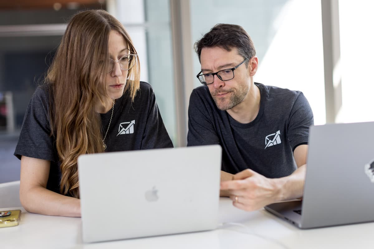 Two colleagues looking at a laptop screen