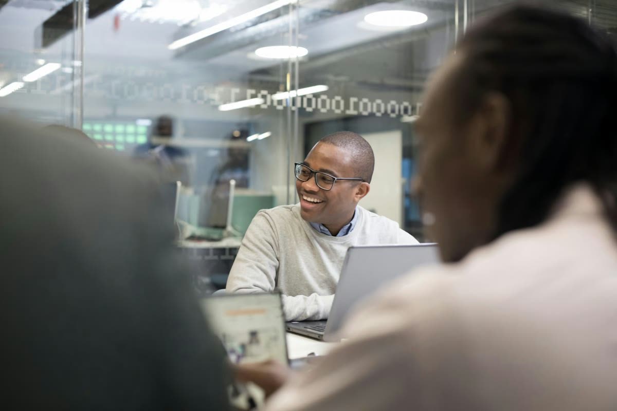 Colleagues talking at a desk in an open-plan office