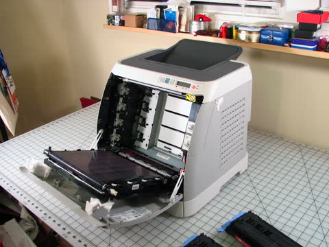 HP Color LaserJet 2600n with its front open on a workbench