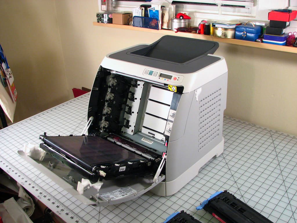 HP Color LaserJet 2600n with its front open on a workbench