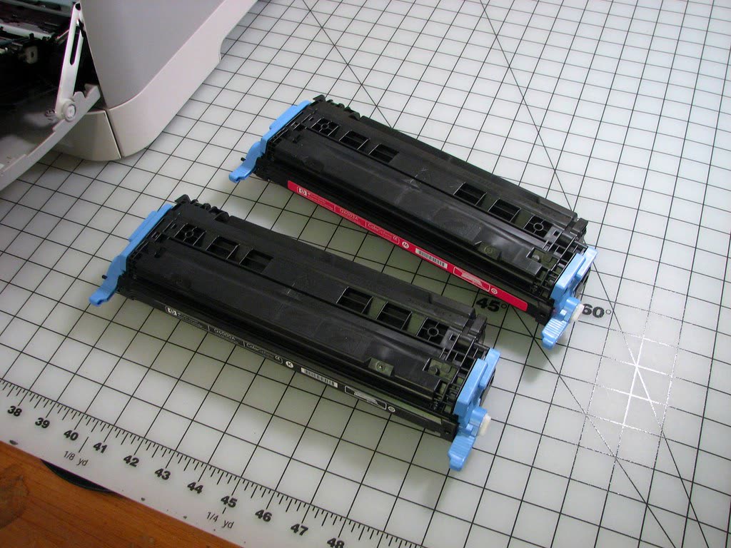 HP Color LaserJet toner cartridges laid on a cutting mat