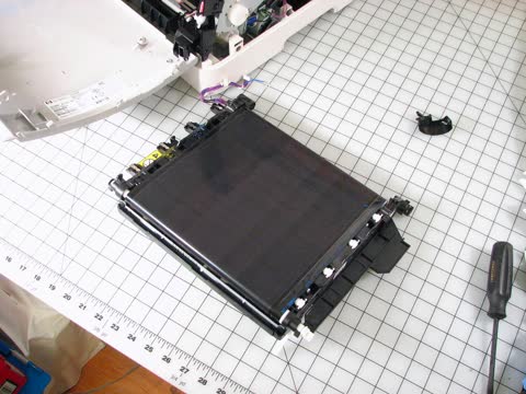 Transfer belt unit from an HP Color LaserJet 2600n on a workbench