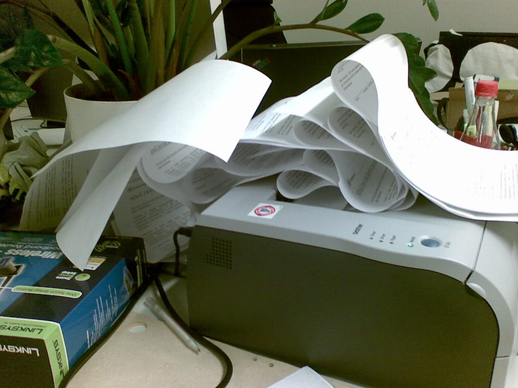Paper jammed and curling out of a laser printer