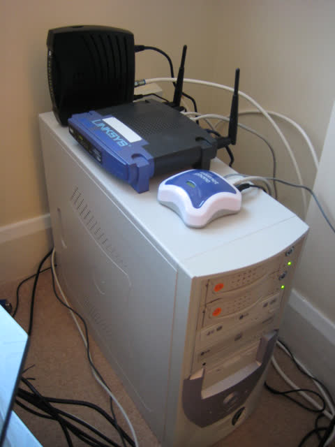Wireless router and cable modem on top of a desktop computer