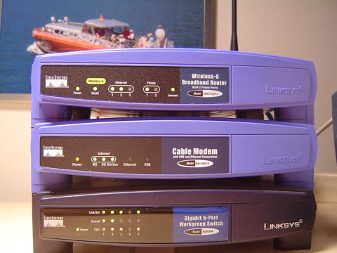 Stack of a Linksys router, cable modem and network switch