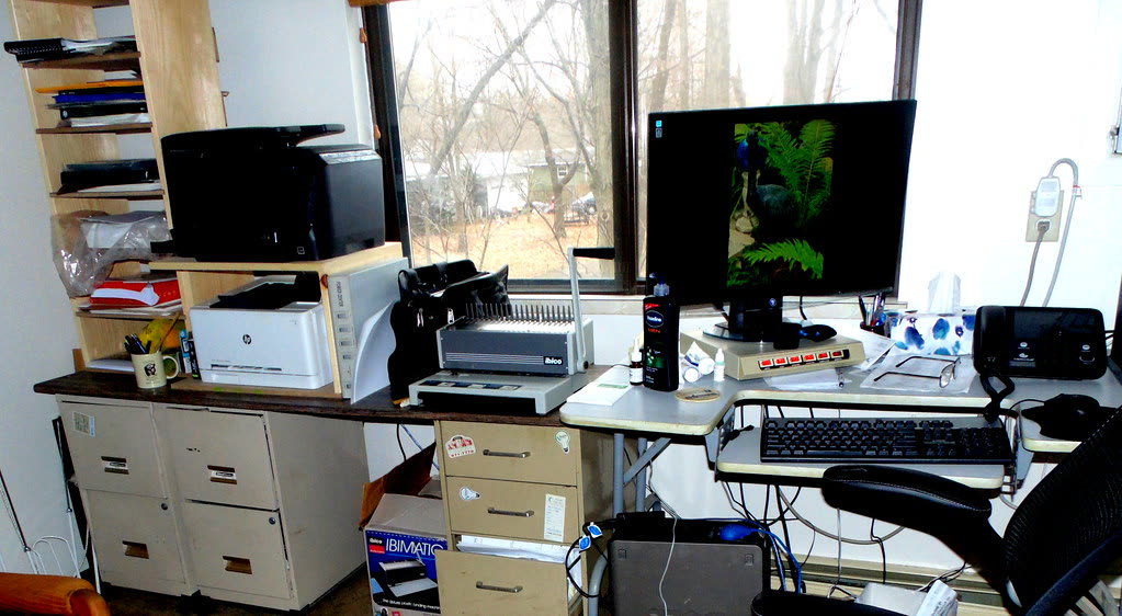 Home office desk with an inkjet printer, computer and paperwork